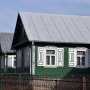 Drewniana zabudowa. Rząd ustrojonych bogatymi zdobieniami dom&oacute;w rozpoczyna się na posesji nr 12.